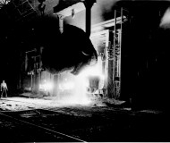 Photograph_of_a_Vat_of_Molten_Pig_Iron_Being_Poured_into_a_Open_Hearth_Furnace_at_the_Jones_and_Laughlin_Steel_Company,_Pittsburgh,_Pennsy_-_NARA_-_535922_(high_contrast).jpg